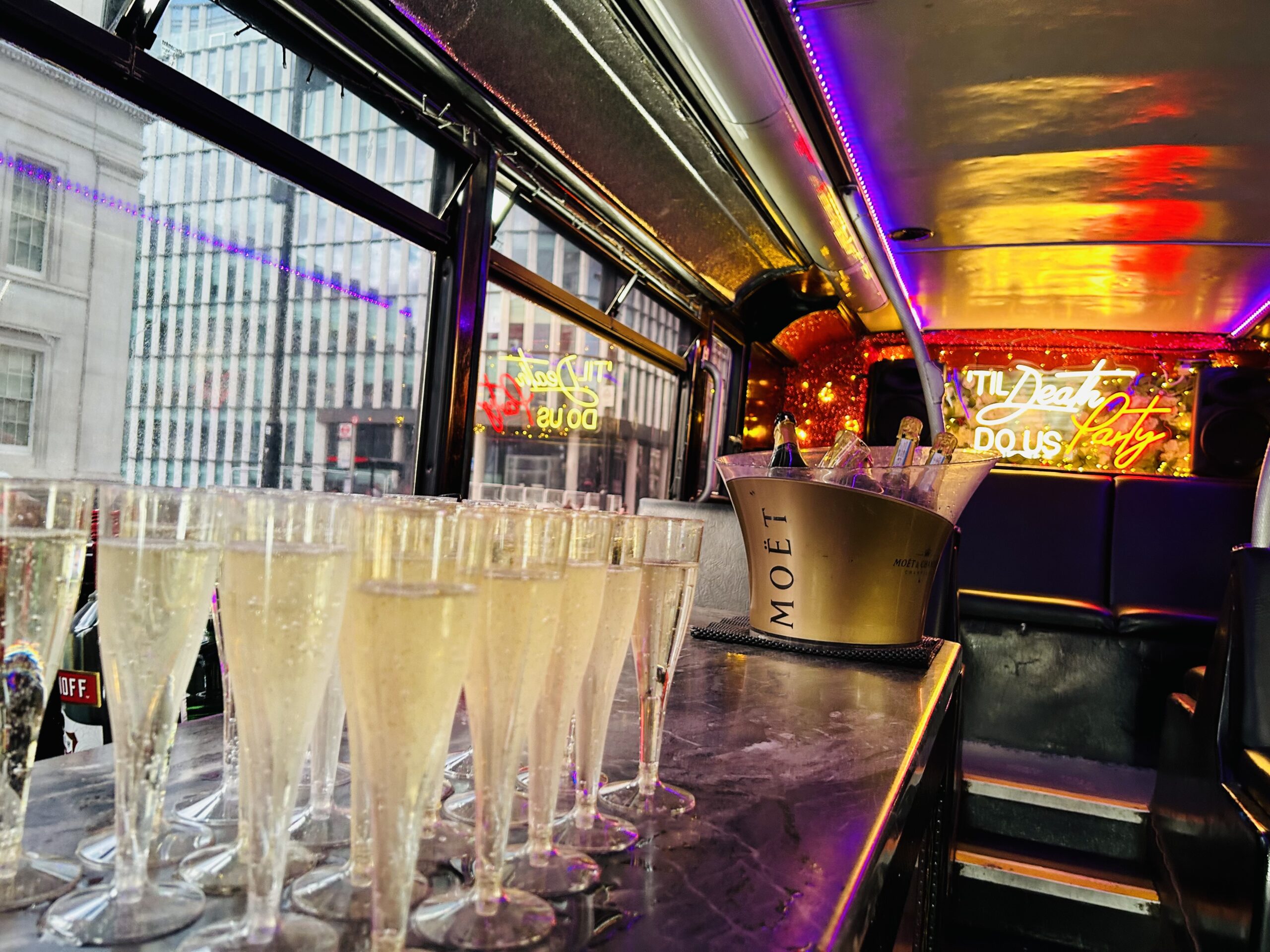 Champagne poured and waiting at the bar on board a Champagne Tours London party bus
